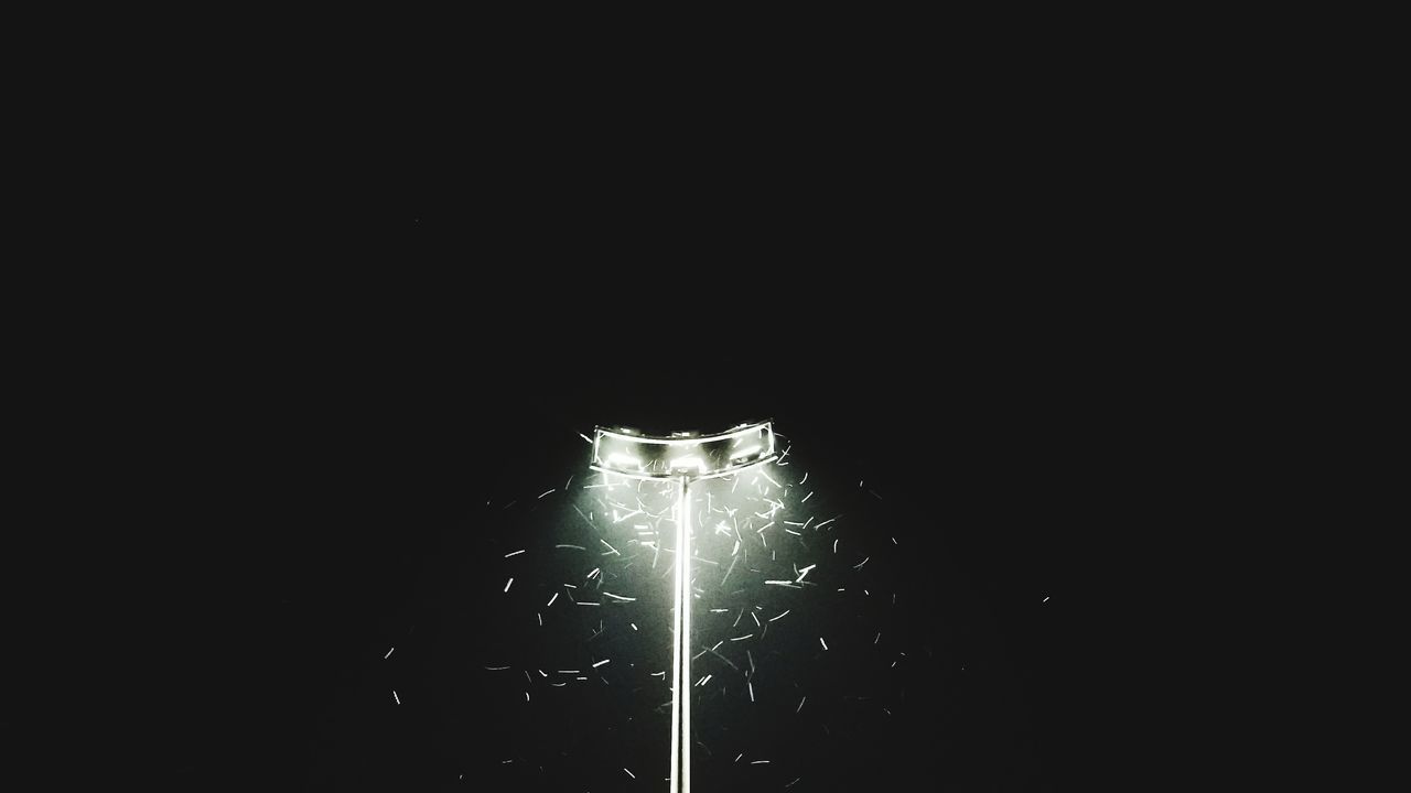 LOW ANGLE VIEW OF ILLUMINATED LAMP AGAINST BLACK BACKGROUND