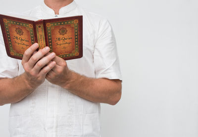 Midsection of man holding text against white background