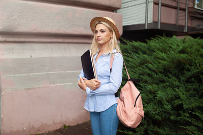 Full length of young woman standing on mobile phone