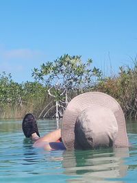 Boy in water against clear sky