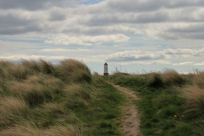 Lighthouse on land against sky