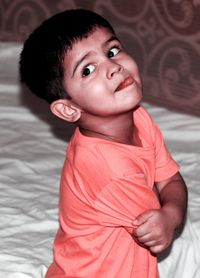 Portrait of cute baby girl on bed at home