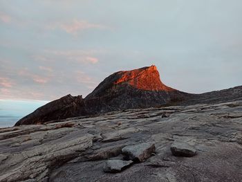 Rock formations on land against sky during sunset