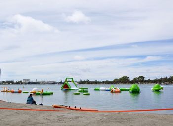 Boats in sea against cloudy sky