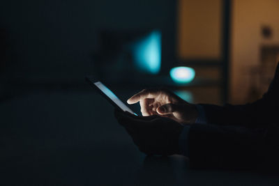 Close-up of businessman working late in office using tablet