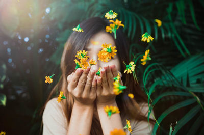 Woman blowing orange flowers