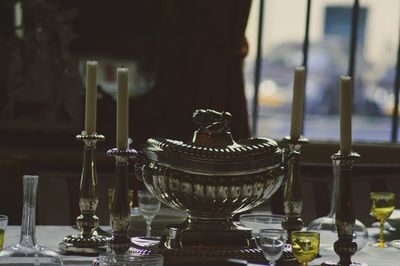 Close-up of candles with kitchen utensils on table
