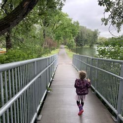 Rear view of girl walking on footbridge