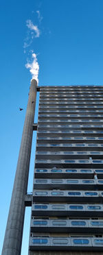 Low angle view of modern building against blue sky