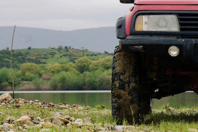 Cropped image of car by lake