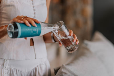 Midsection of woman drinking water