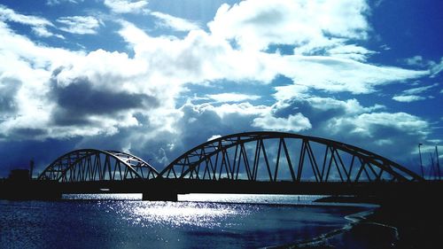 Low angle view of bridge over river against sky