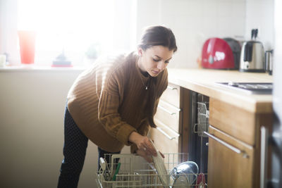 Young woman doing house work in the kitchen