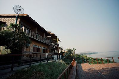 Footpath by building against clear sky