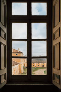 Buildings against sky seen through glass window