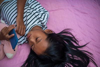 High angle view of woman relaxing on bed