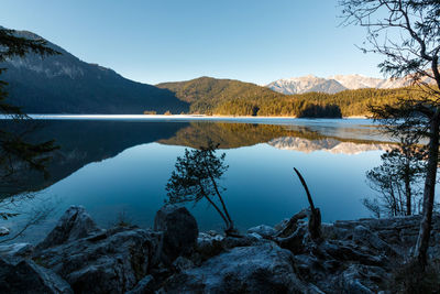 Scenic view of lake by mountains against sky