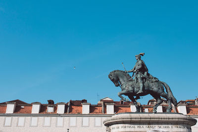 Low angle view of statue against blue sky