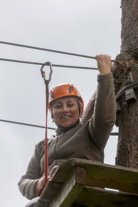 Low angle view of smiling woman standing against the sky