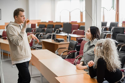 Rear view of female friends working in meeting