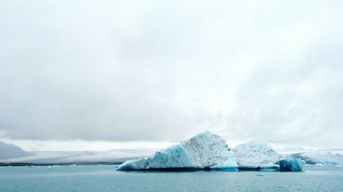 Scenic view of icebergs at jokulsarlon against sky