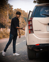 Side view of young man standing in city