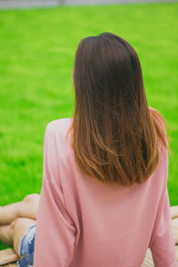 Rear view of woman sitting on footpath