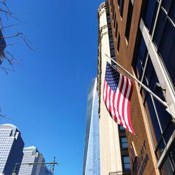 Low angle view of flag against blue sky