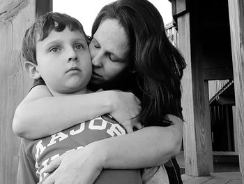 Low angle view of mother embracing son