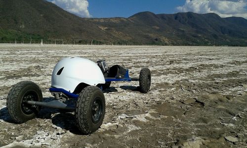 Motorcycle on sand against mountain range