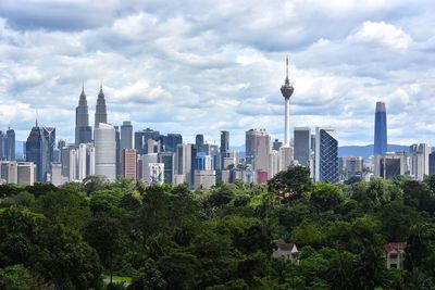 View of buildings in city against cloudy sky