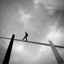 Low angle view of man walking on rope