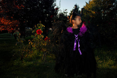 Girl with maleficent costume, playing in the woods