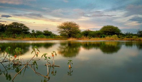 Scenic view of lake against sky at sunset