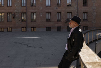 Portrait of adult man in hat and leather jacket on street. madrid, spain