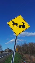 Low angle view of information sign against blue sky