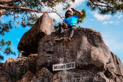 Low angle view of senior man on rock