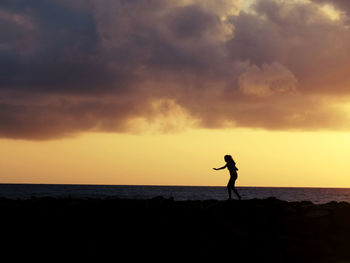 Silhouette of people on beach at sunset