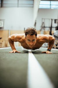 Shirtless man exercising in gym