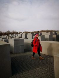 Full length of woman standing by road against sky