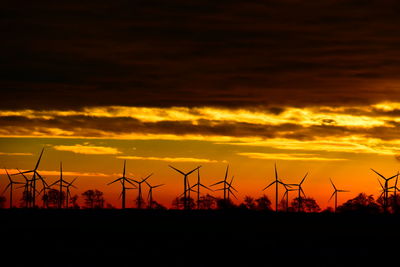 Low angle view of silhouette plants against orange sky