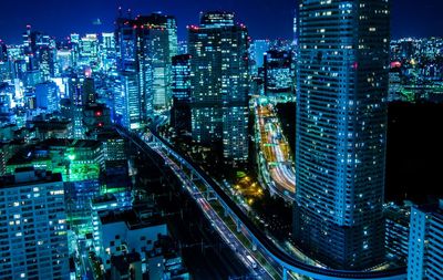 High angle view of illuminated cityscape against sky at night