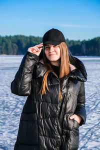 Young female smiling and looking at a camera in a snow landscape. happy hipster girl with hip hop