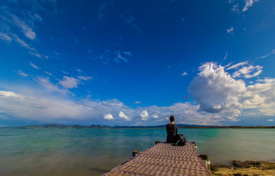 Rear view of woman overlooking calm sea