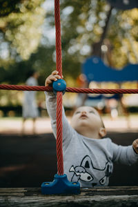 Low angle view of swing hanging on rope at playground