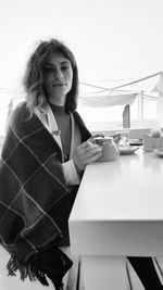 Portrait of young woman sitting at table