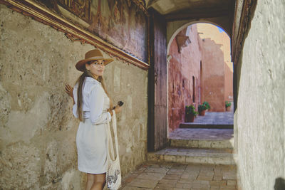 Rear view of woman standing against wall