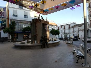 Chairs and tables on street amidst buildings in city