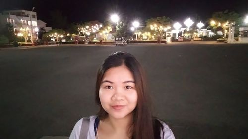 Portrait of beautiful woman in city at night