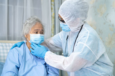 Doctor examining senior woman at hospital